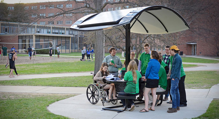 The student group, Sustainable Spartans, gather around the newly installed solar picnic table.