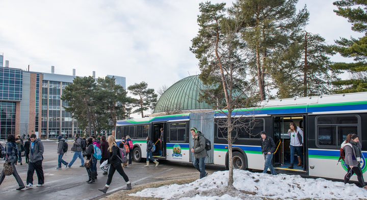 Students disembark from a CATA bus in the winter.