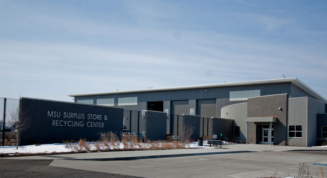 A photo of the MSU Surplus and Recycling Center building, looking across the parking lot.