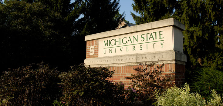 A photo of a campus entryway marker, prominently featuring Michigan State University's logo.