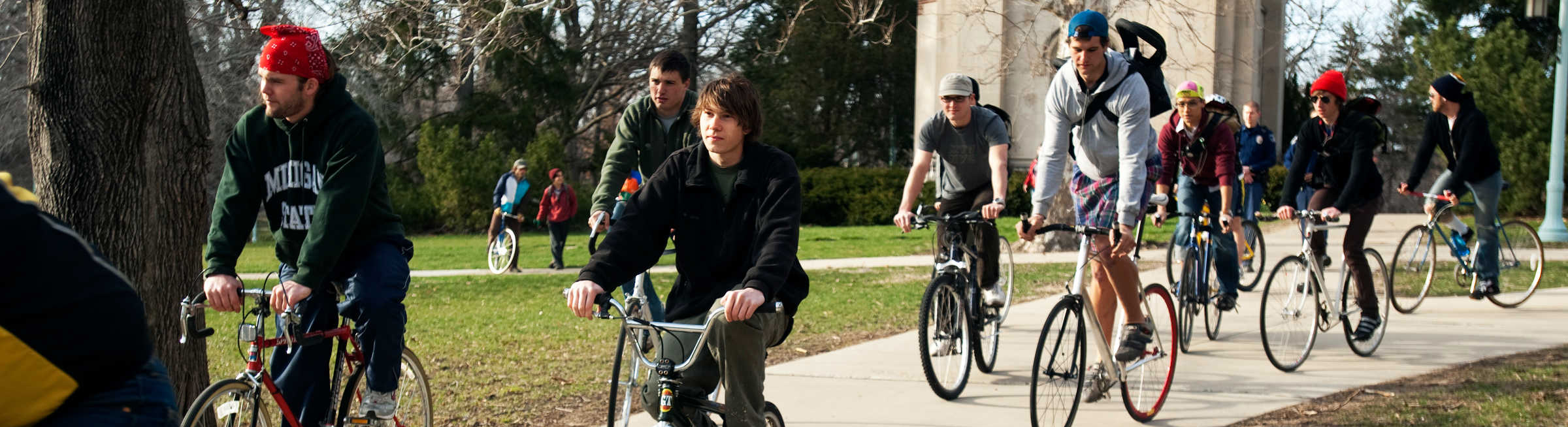 Students riding bikes along a campus path.