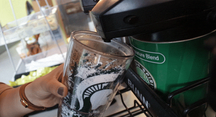 A short video GIF that shows someone filling a reusable coffee thermos at a Sparty's coffee station.